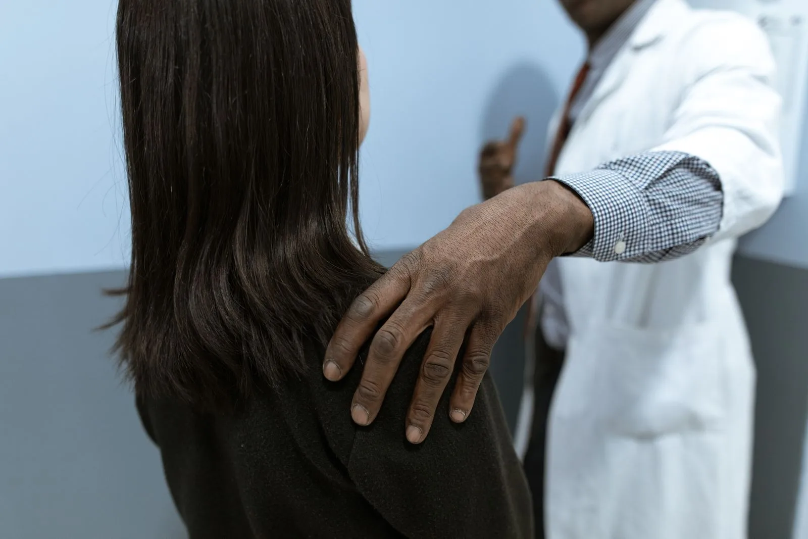 Doctor de DST Clinic acompañando a un paciente con la mano en el hombro